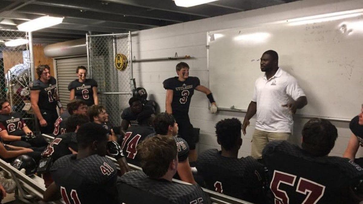 Ovie Mughelli addressing a team in front of a whiteboard