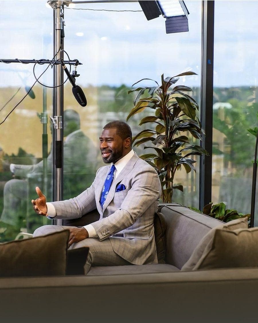 Ovie Mughelli in a tailored suit during a studio interview